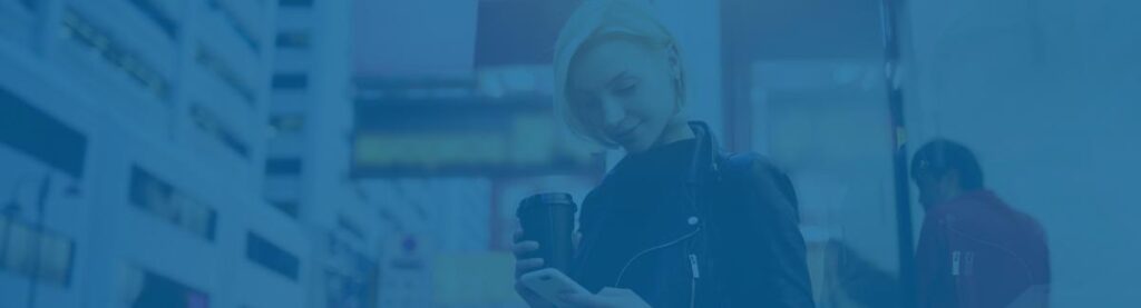 woman holding cup of coffee and her iphone