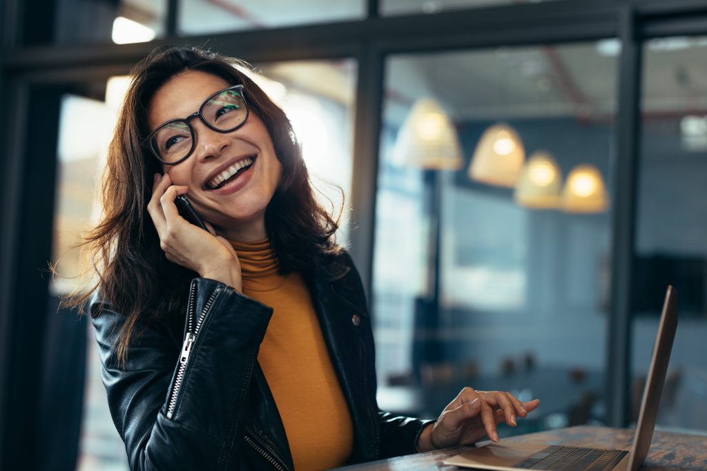 Smiling business woman in casuals talking on phone