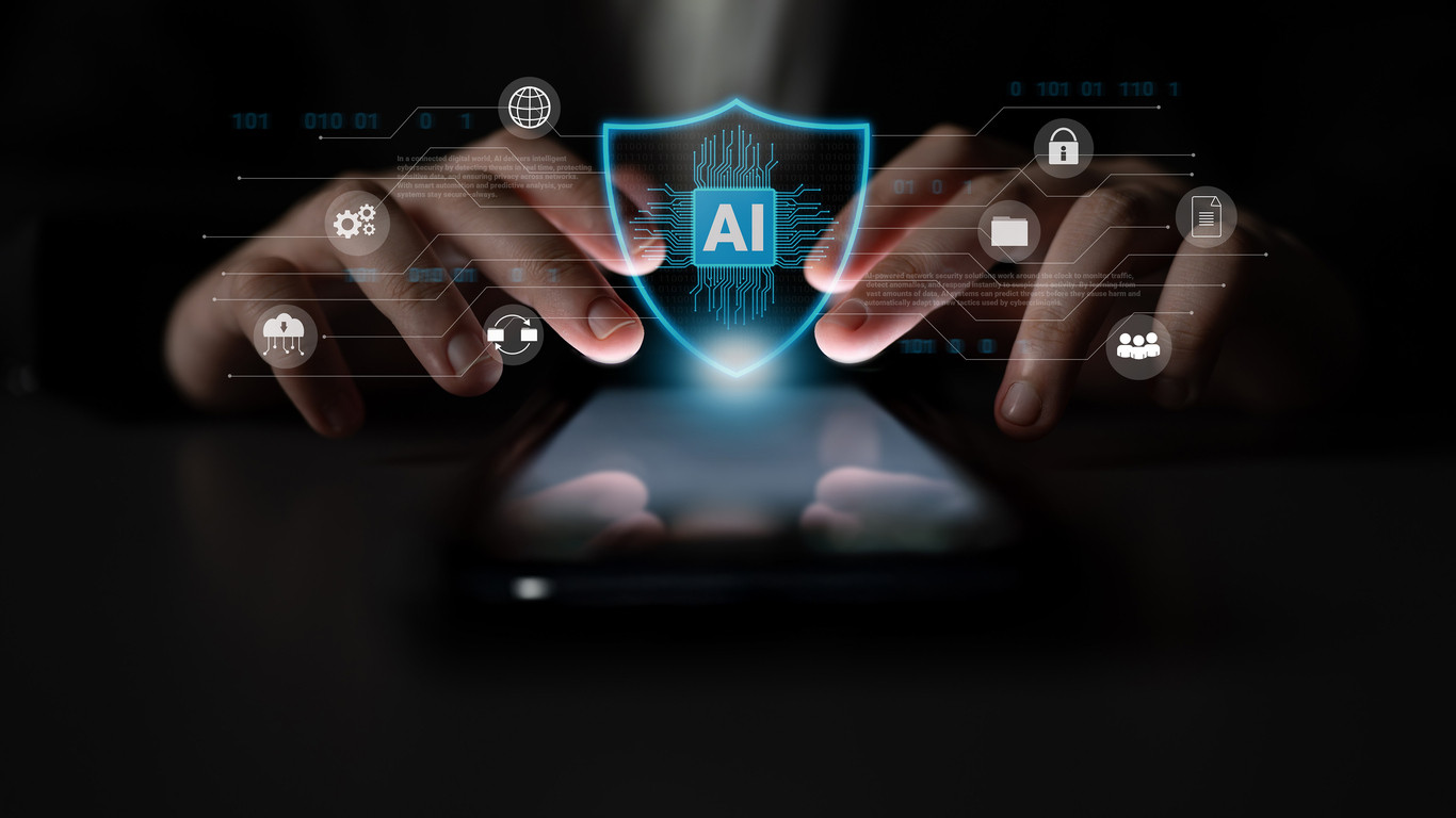Hands Holding Shield with AI Symbol Representing Cybersecurity and Technology Protection Over a Mobile Device